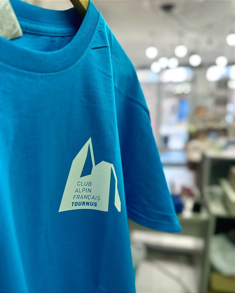 Détail du logo d’un club alpin sur un t-shirt bleu
